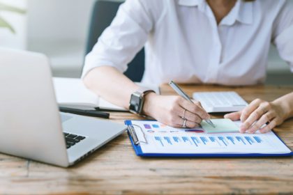 Close-up of businesswoman analyzing chart and graph showing changes on the market.