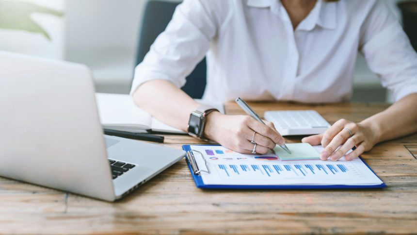 Close-up of businesswoman analyzing chart and graph showing changes on the market.