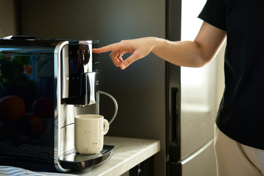 Woman Preparing Fresh Cup of Coffee With Modern Espresso Machine