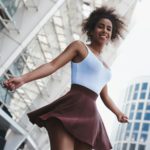 Young woman in skirt free style on the street spinning looking d