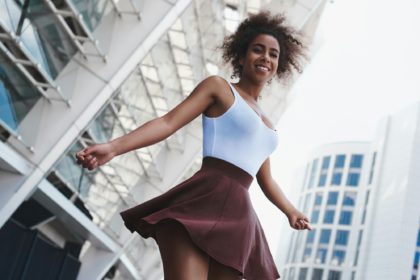 Young woman in skirt free style on the street spinning looking d